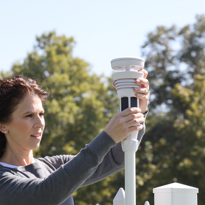 Installing the Tempest device on a pole.